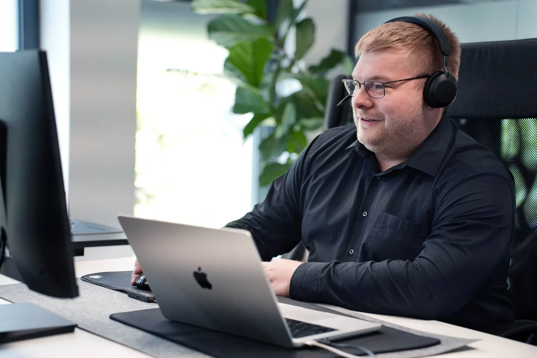 Mitarbeiter von Haag & Sondershausen arbeitet mit Headset am Schreibtisch